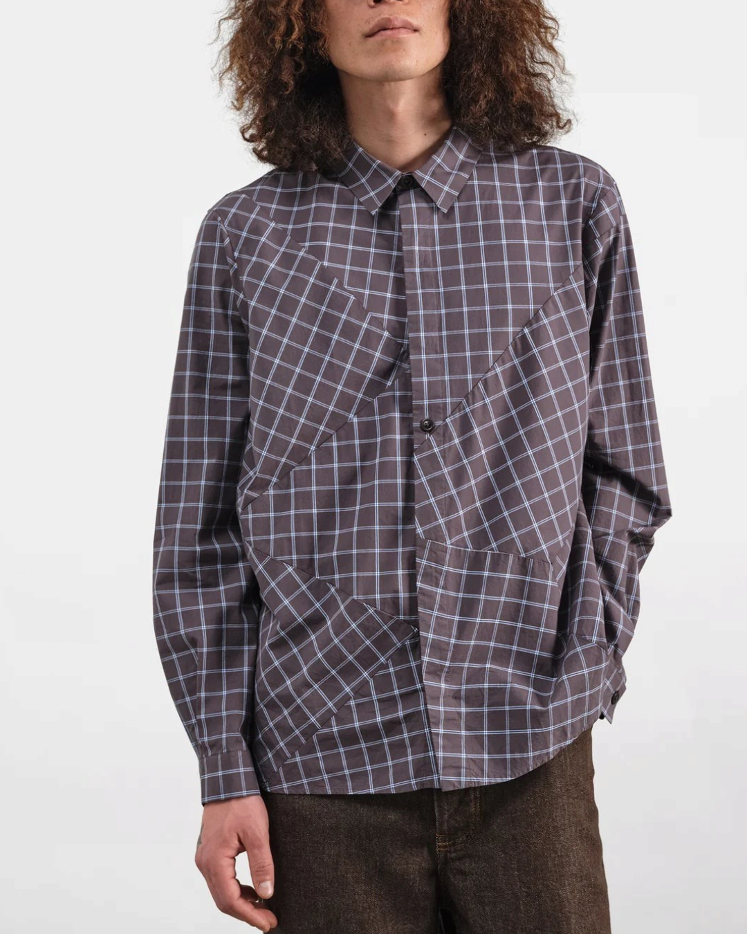 Homme portant la chemise Substance Merci Paris en coton gris à carreaux avec empiècements asymétriques et boutonnage