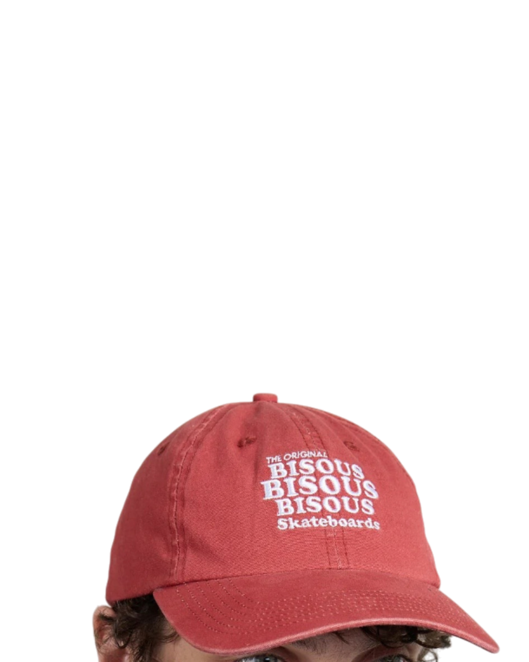 Casquette Merci Paris Bisous Skateboard en coton rouge brique délavé avec broderie blanche portée par un mannequin