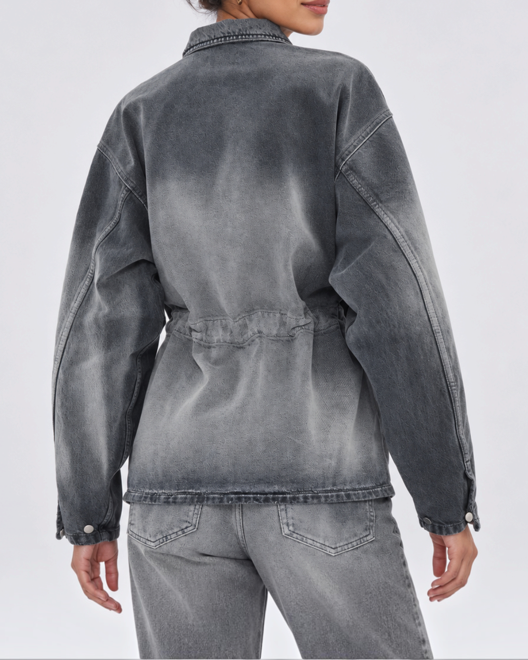 Rear view of Legacy Haikure shirt in washed gray denim with adjustable gathered back, worn by a woman