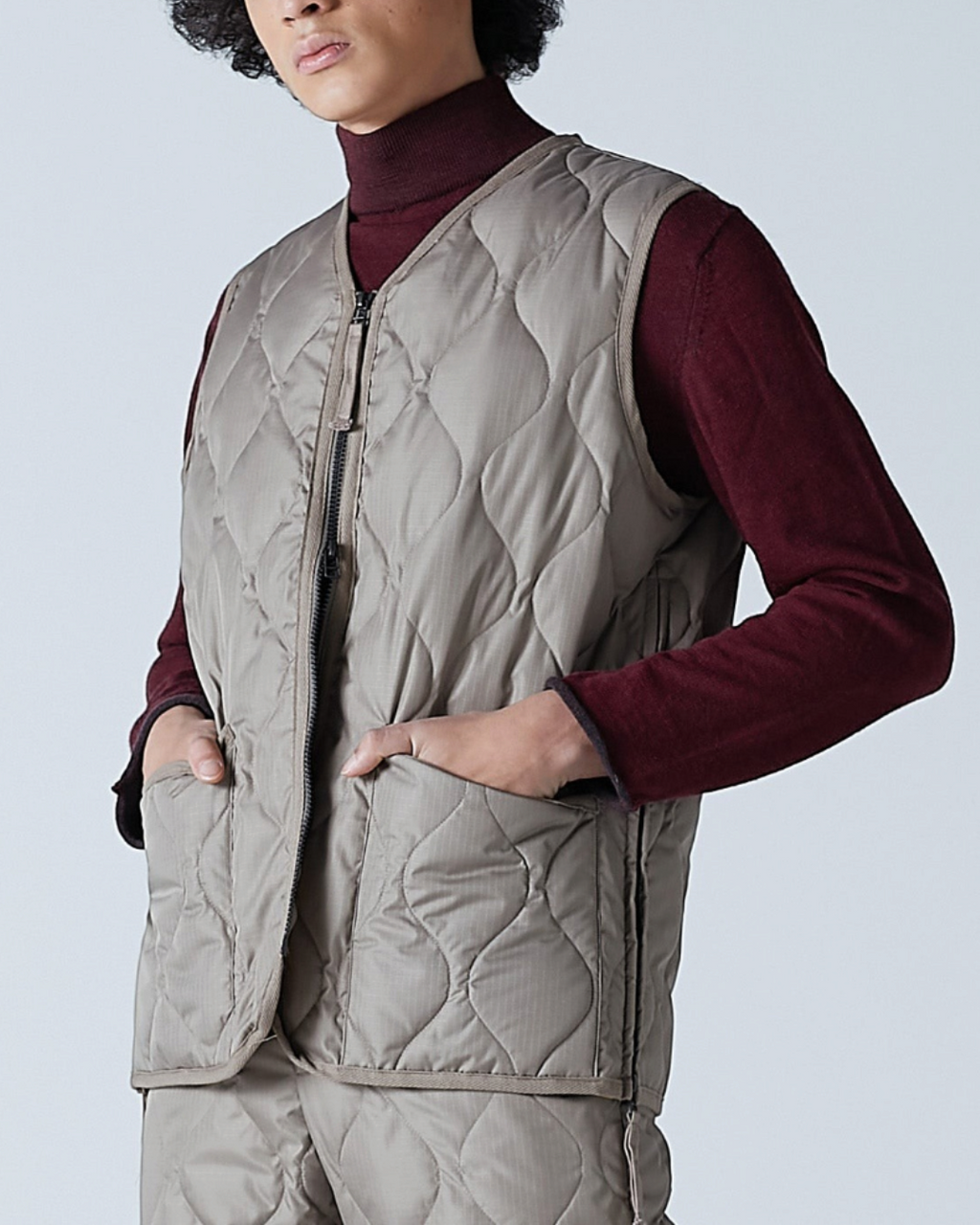Homme portant un gilet matelassé Merci Paris Taion couleur moka avec col en V, zip et tissu ripstop