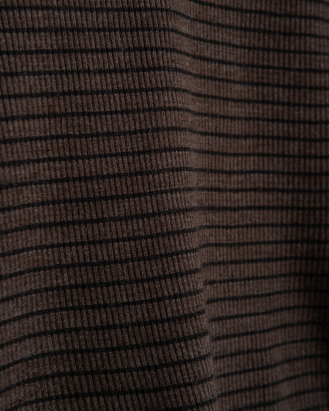 Gros plan sur la maille côtelée rayée marron et noire du pull col roulé Girls Of Dust chez Merci Paris