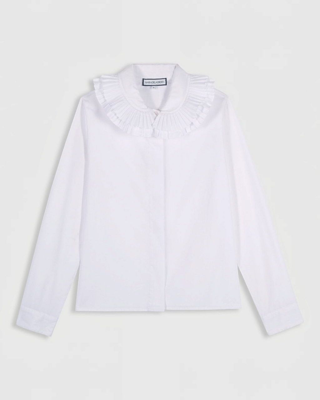 Chemise blanche Maria De La Orden chez Merci Paris avec un double col volanté élégant et une coupe classique