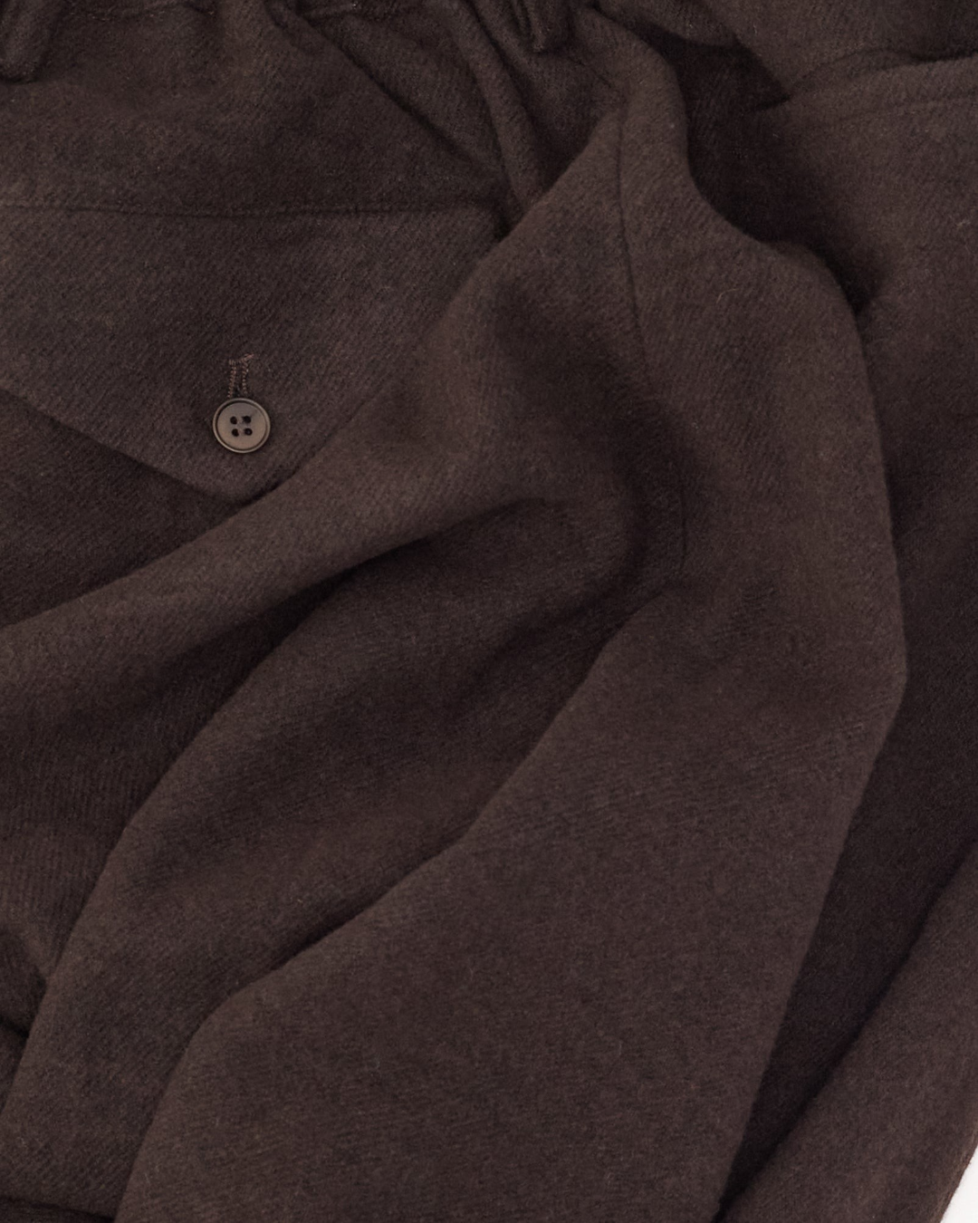 Gros plan sur le pantalon Camp Merci Paris en mélange de laine et cachemire prune foncé avec bouton en corozo