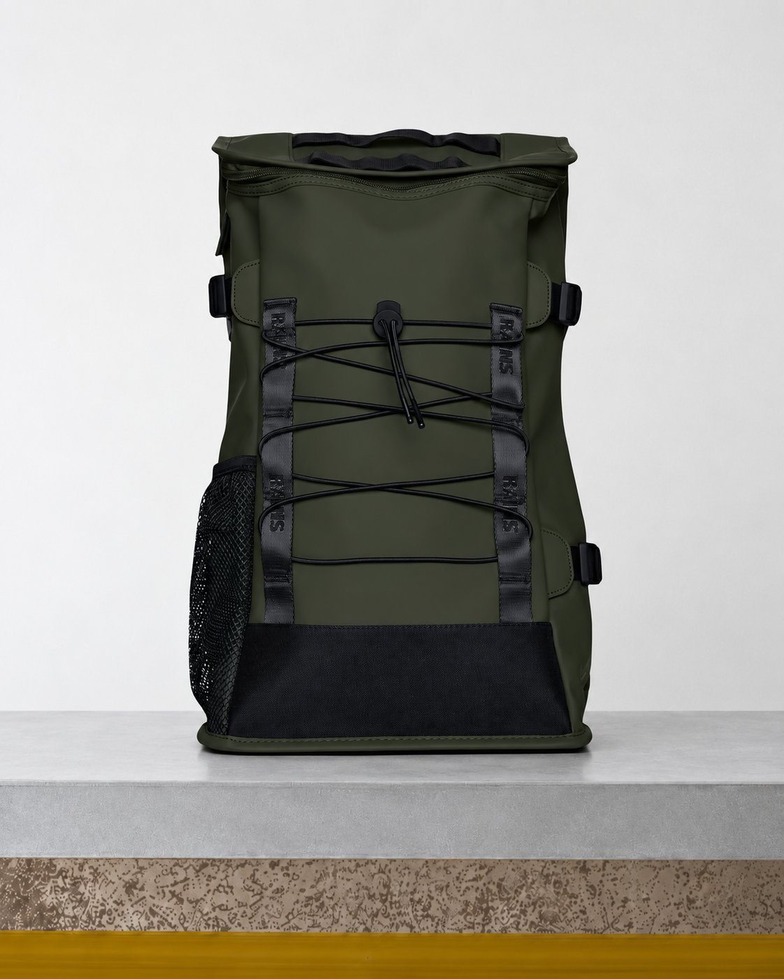 Rains - Sac à dos Trail Mountaineer - Vert posé sur le banc