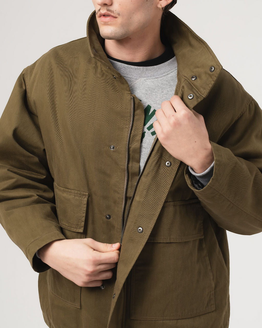 Veste Airborne Merci Paris en coton ciré kaki avec fermeture zippée et boutons-pression, style workwear décontracté.