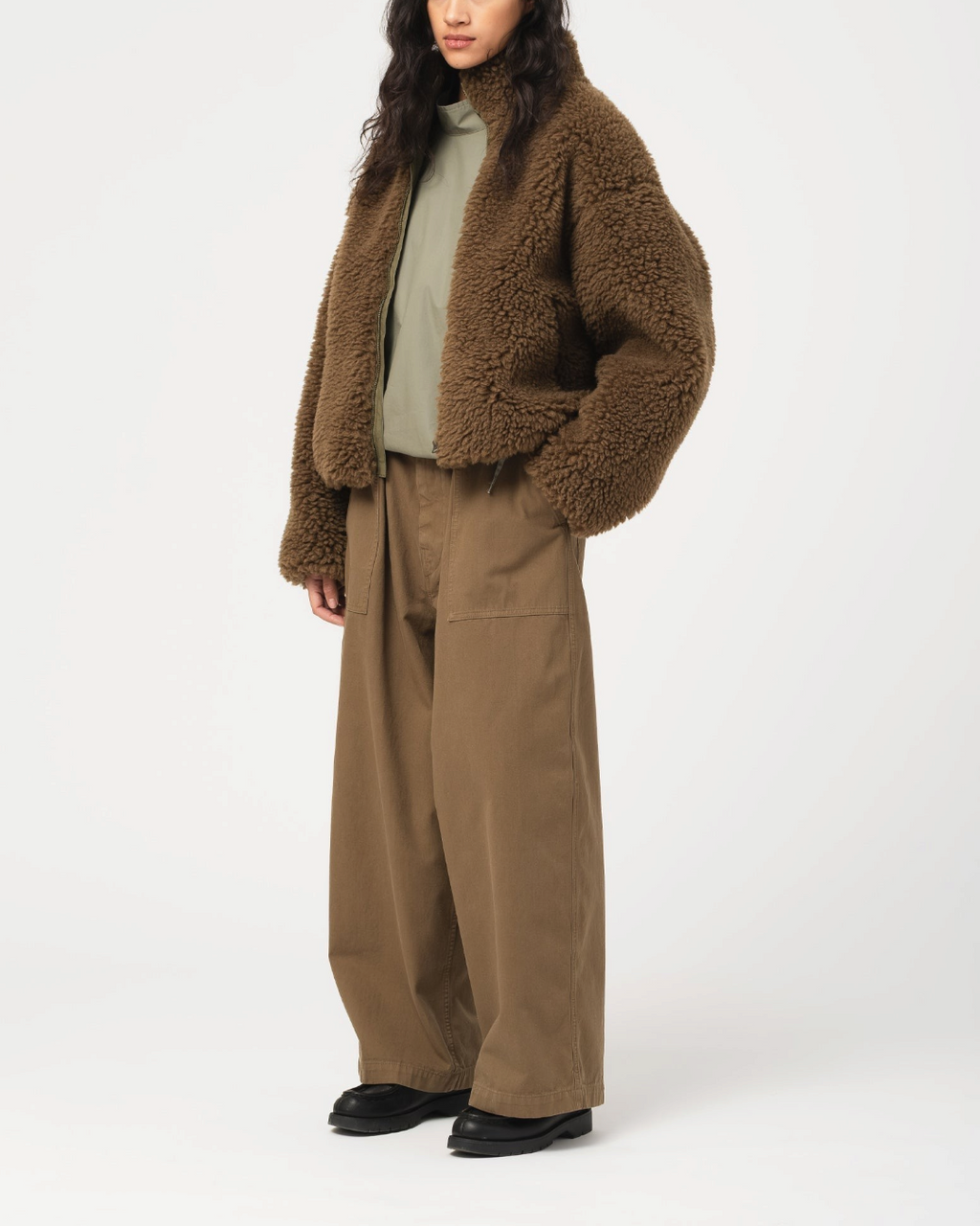 Modèle portant la veste Alpine Jacket marron Shitake de Merci Paris en matière texturée avec col haut structuré