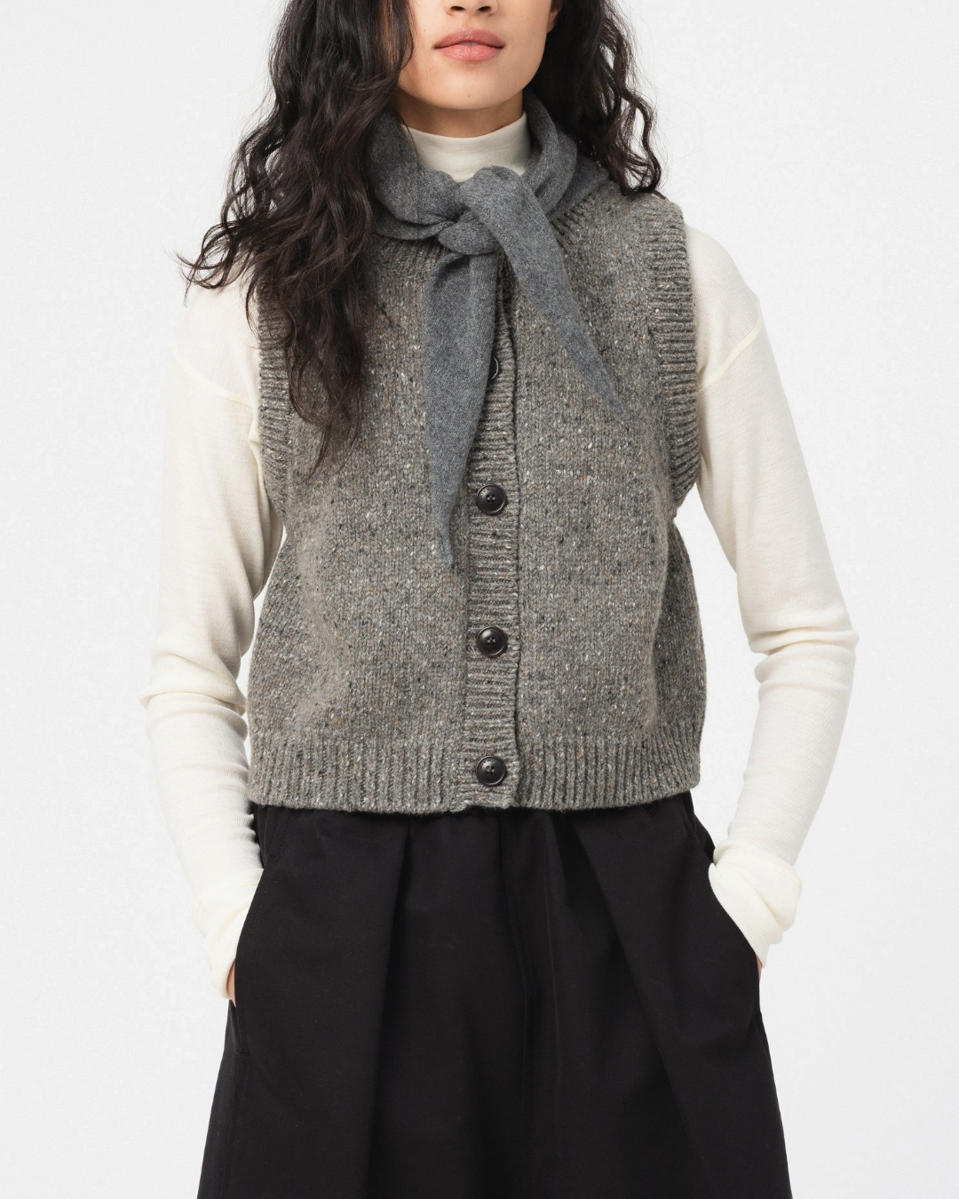 Gilet sans manches Merci Paris Girls Of Dust en laine grise mouchetée avec fermeture boutonnée porté par une femme