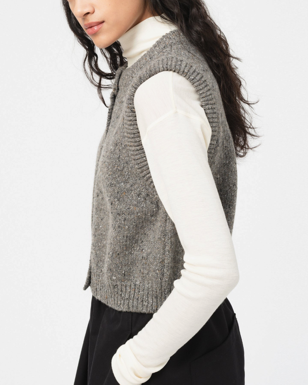 Gilet sans manches Merci Paris Girls Of Dust en laine grise mouchetée porté sur un sous-pull blanc